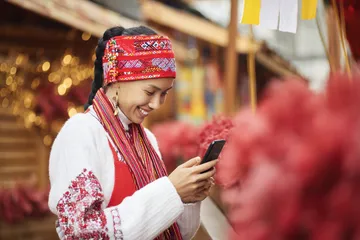 Uma mulher sorrindo perto de máquinas caça-níqueis brilhantes com símbolos de sorte, mostrando as emocionantes opções de slots do POPBEA.